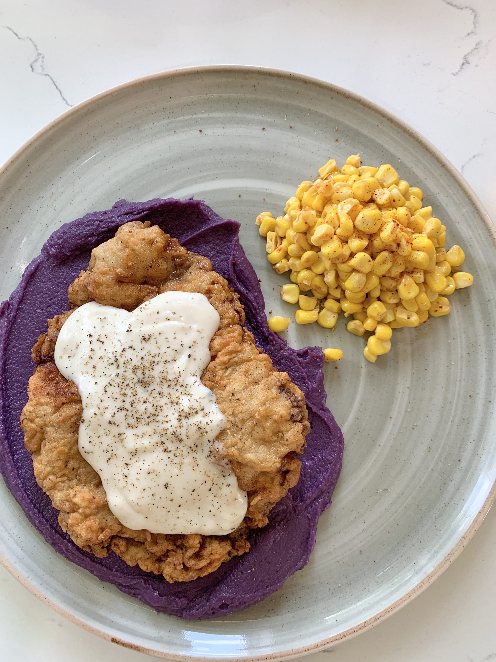 Chicken fried steak on a bed of mashed purple sweet potatoes